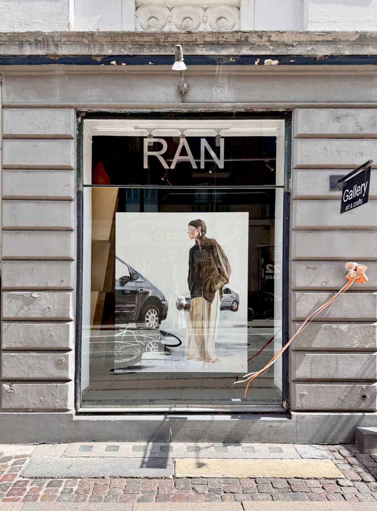 Værk set gennem galleriets vindue fra gaden